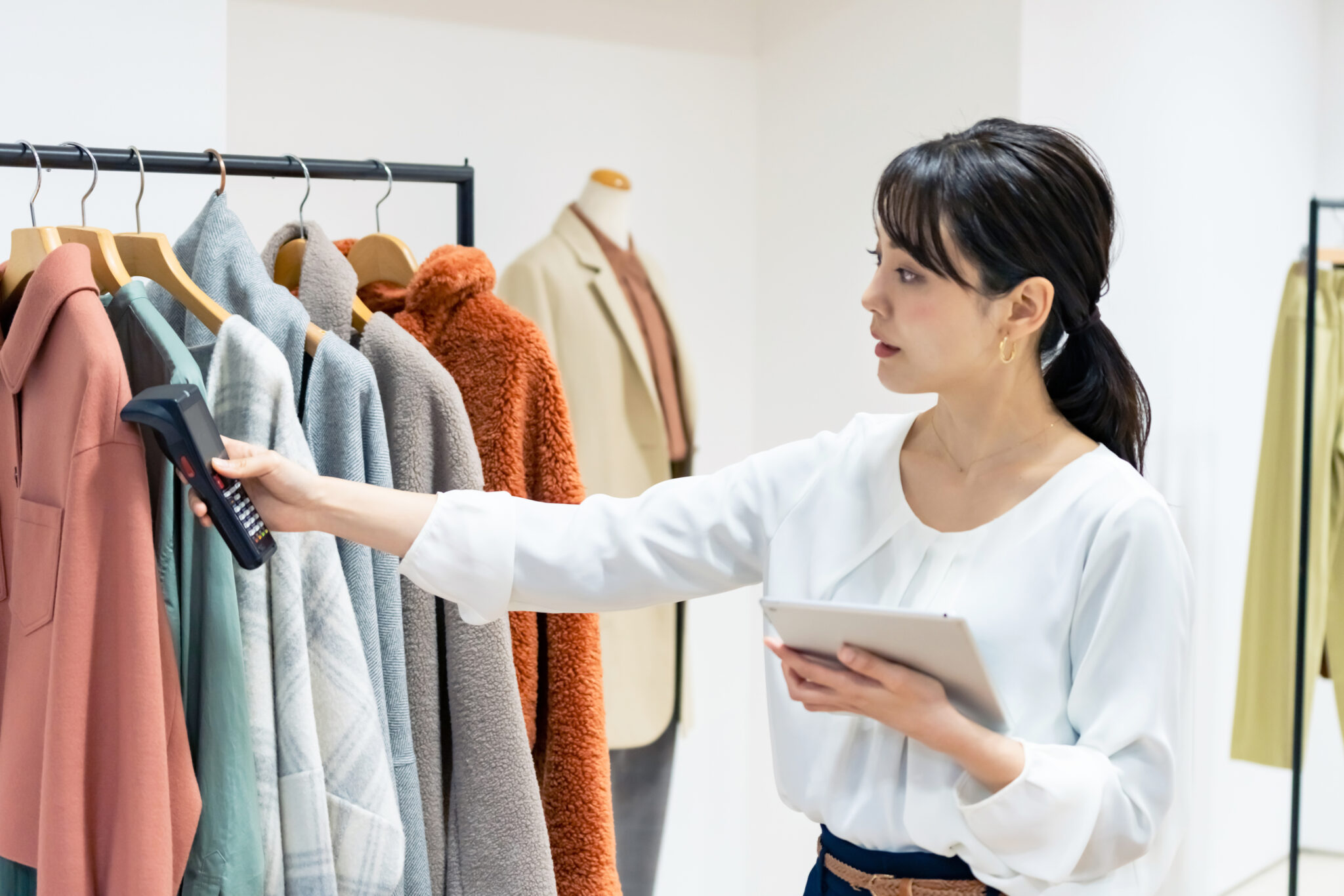 Employée scannant des vêtements dans un magasin.
