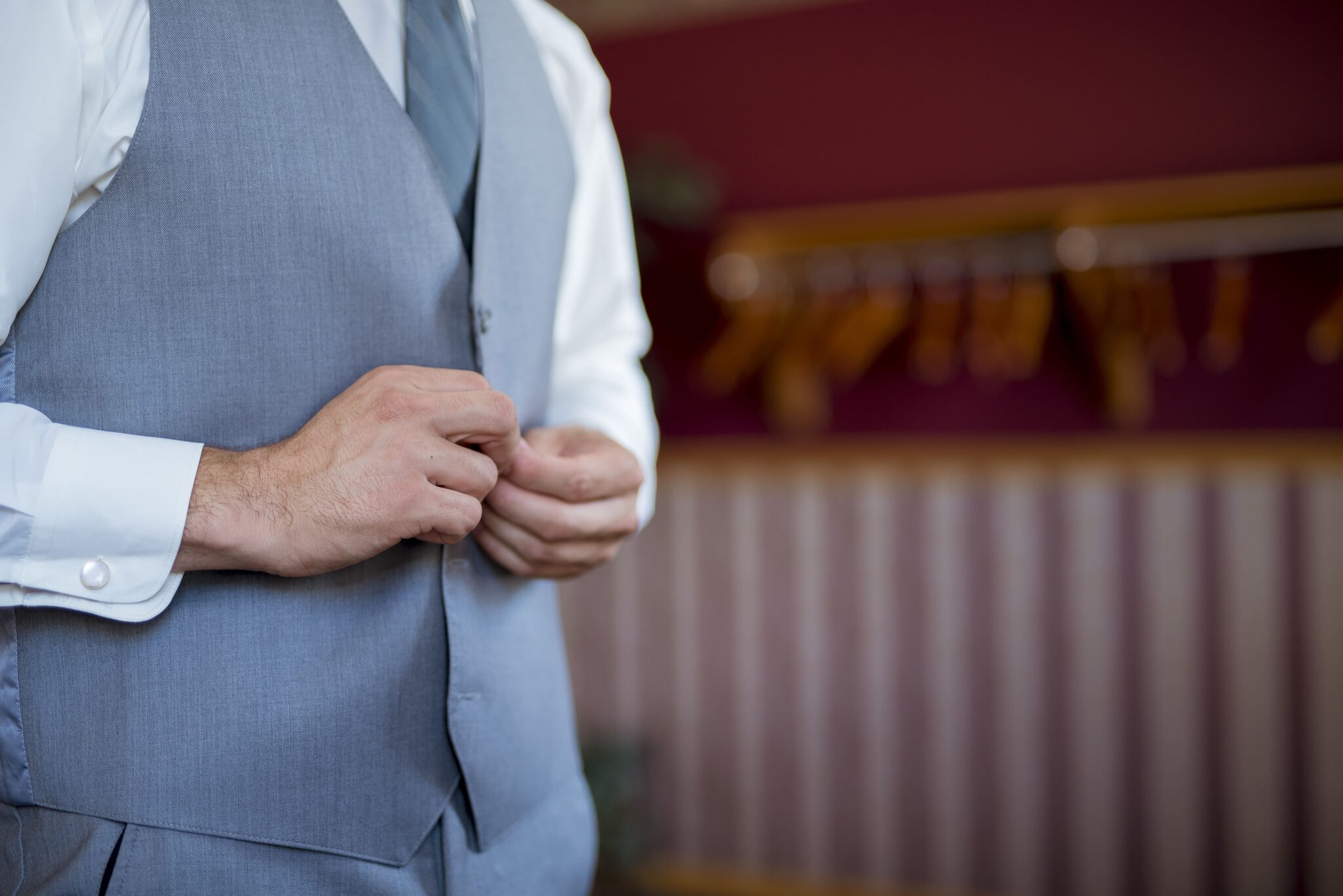 Homme boutonnant son gilet gris élégant