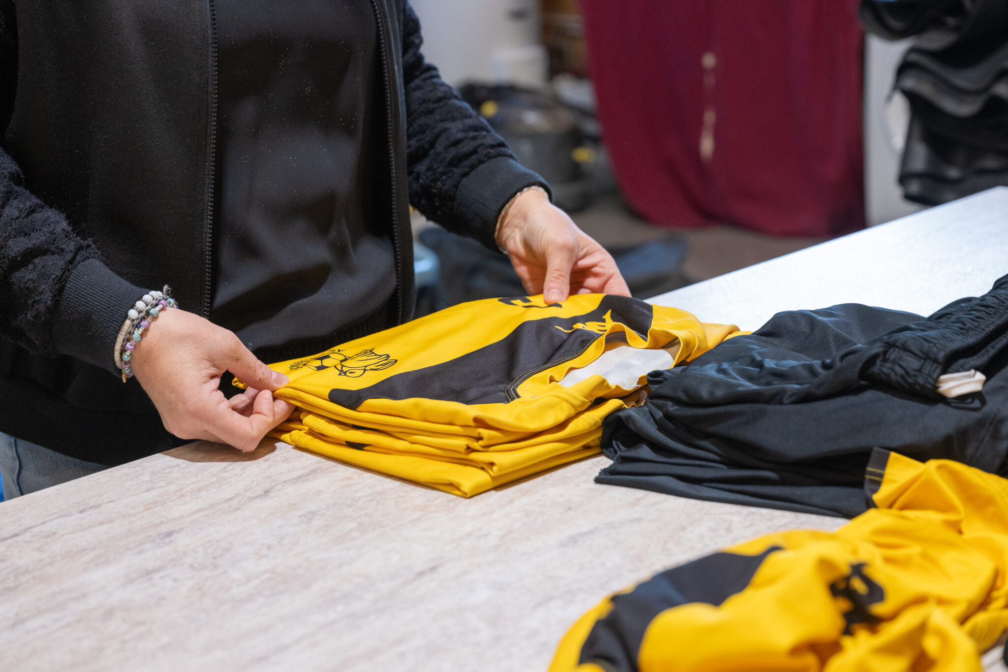 Personne pliant des maillots de sport jaunes