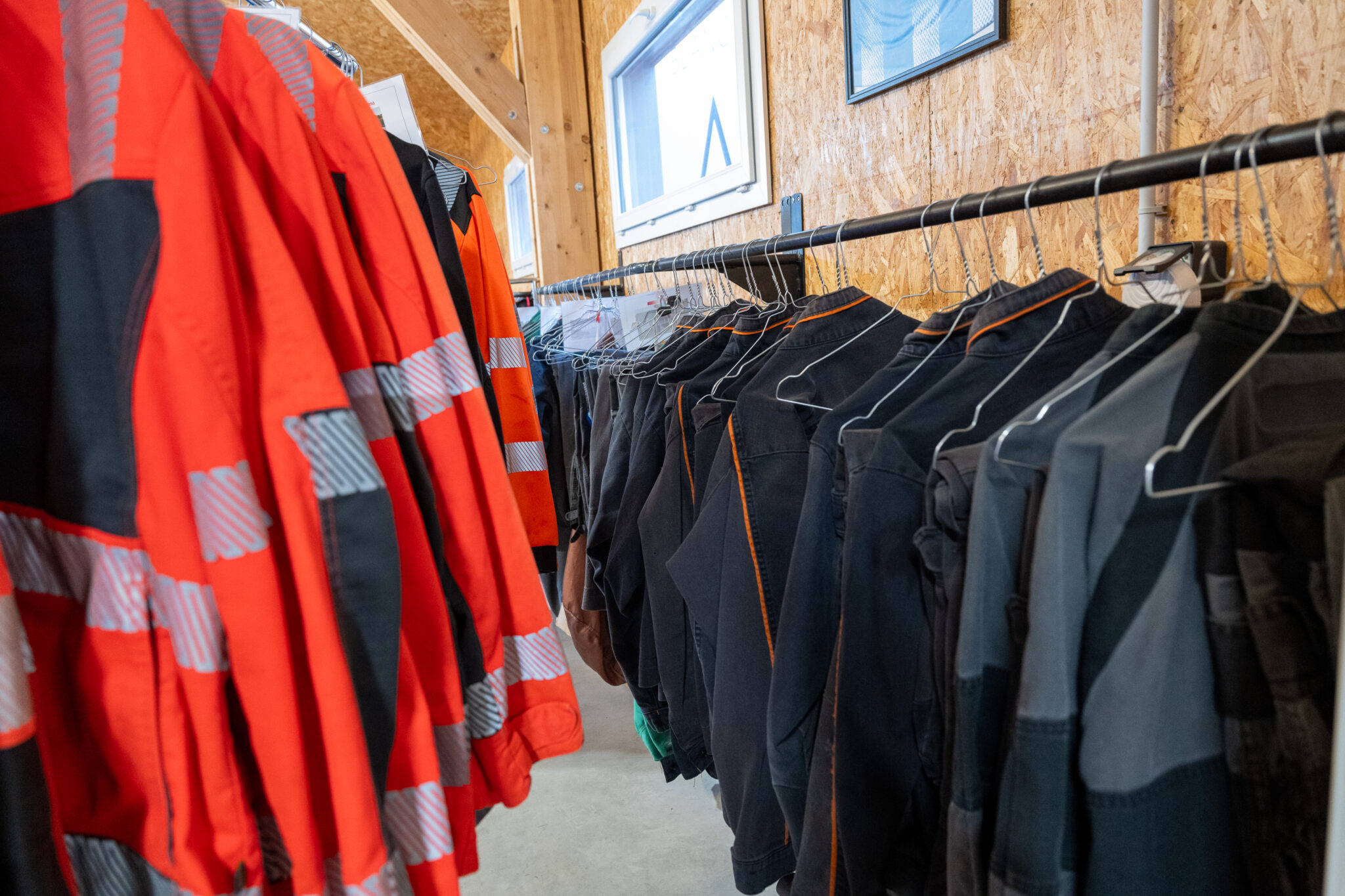 Vêtements de travail suspendus sur des cintres.