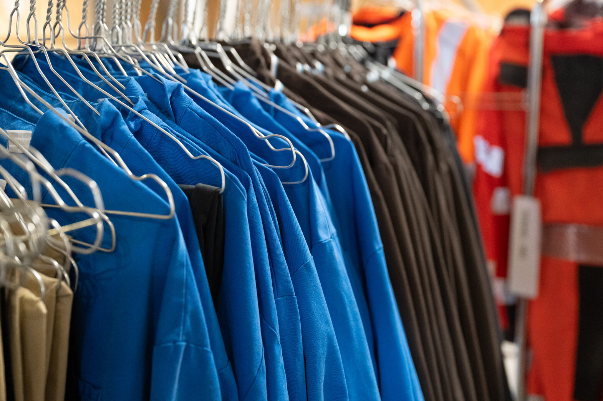 Vêtements de travail suspendus sur des cintres.