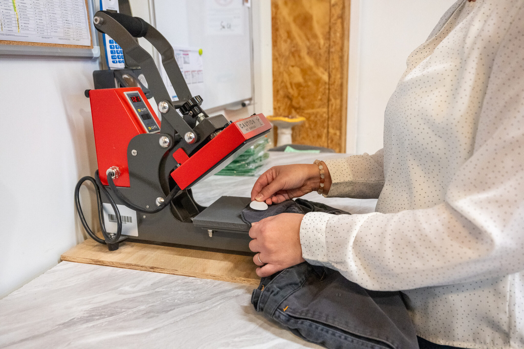 Personne utilisant une presse à chaleur sur un vêtement