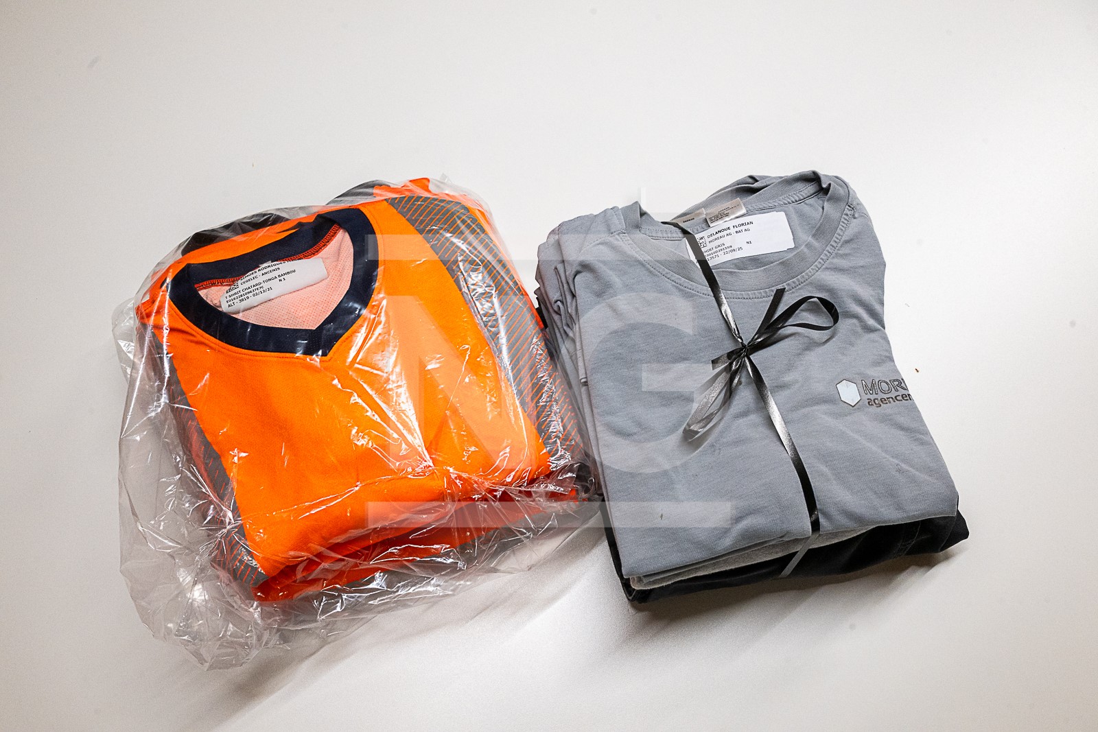 Deux ensembles de vêtements pliés sur une table.